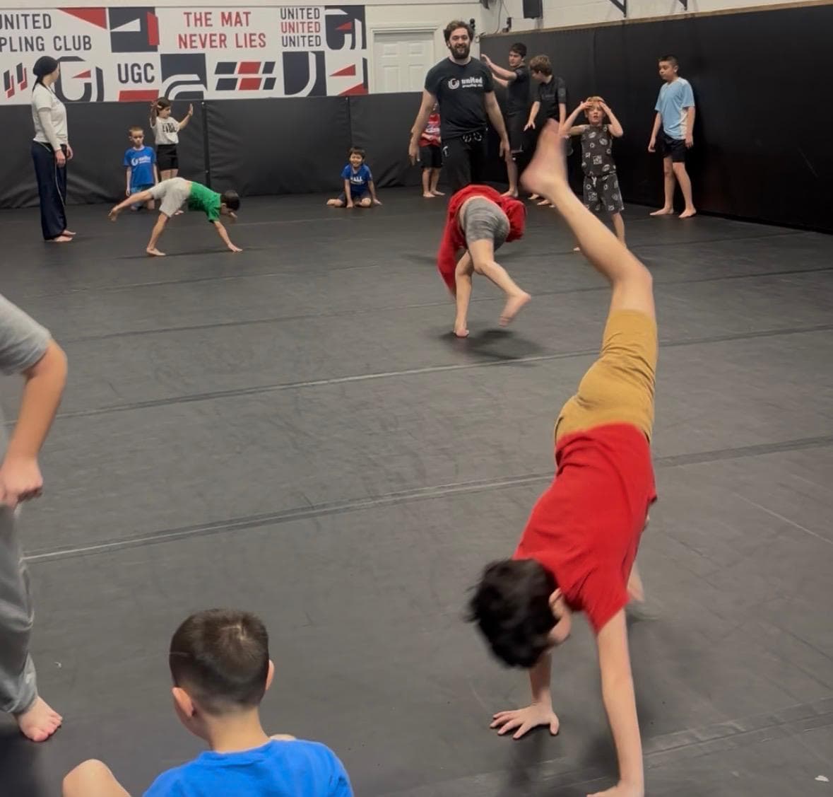 Children practising cartwheels during a movement game at United Grappling Club