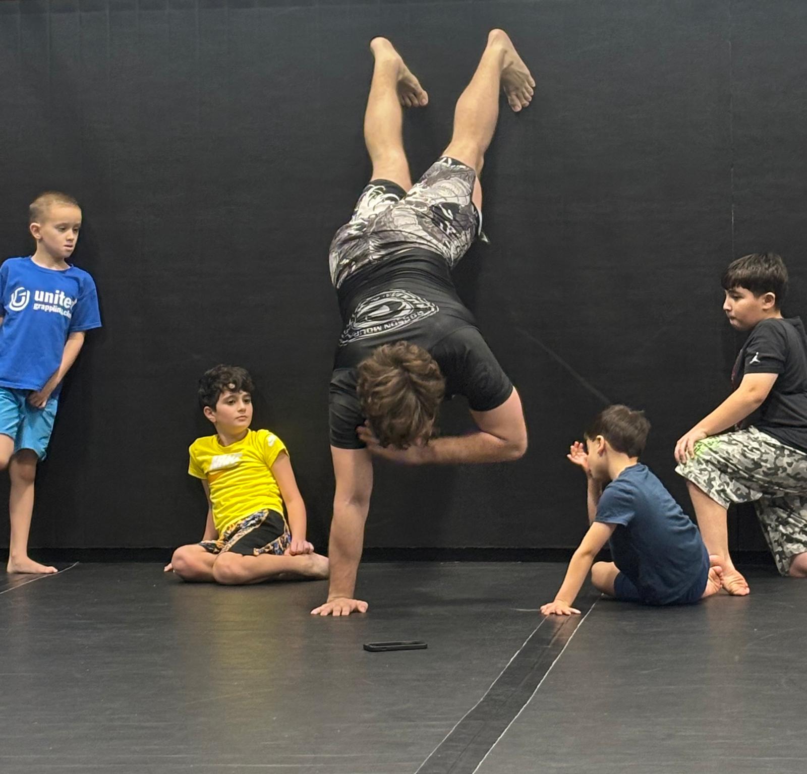 Coach demonstrating a handstand for kids